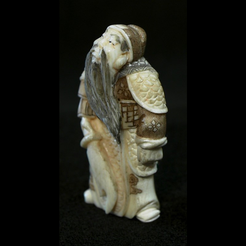 Antico netsuke in avorio raffigurante Shoki con la spada